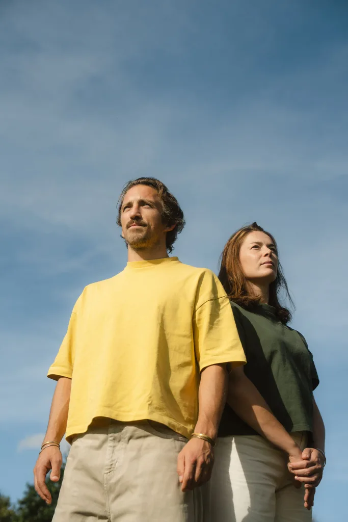 Man en vrouw staan naast elkaar buiten onder een blauwe lucht